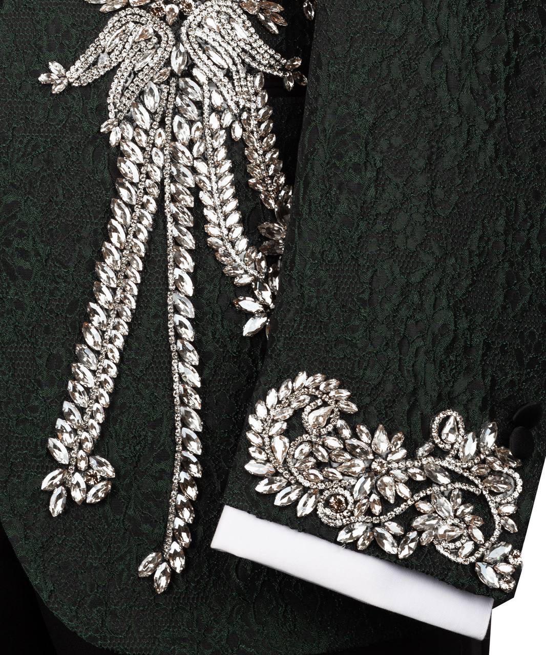 Close-up of decorative silver embroidery on a black fabric background