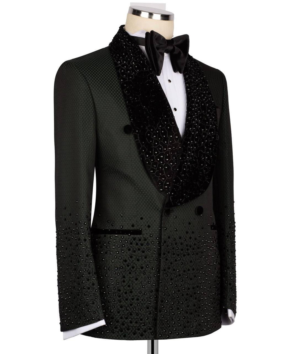 A black tuxedo jacket with sparkling rhinestone embellishments, displayed on a mannequin with a white dress shirt, black bow tie, and a large black beaded collar.