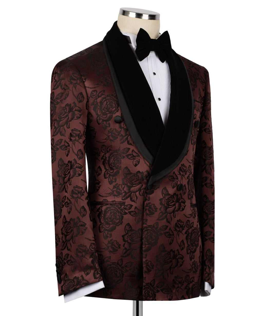 A men's tuxedo jacket displayed on a mannequin torso, featuring a dark brown and black floral brocade pattern, black velvet shawl lapels, a white dress shirt, and a black bow tie.