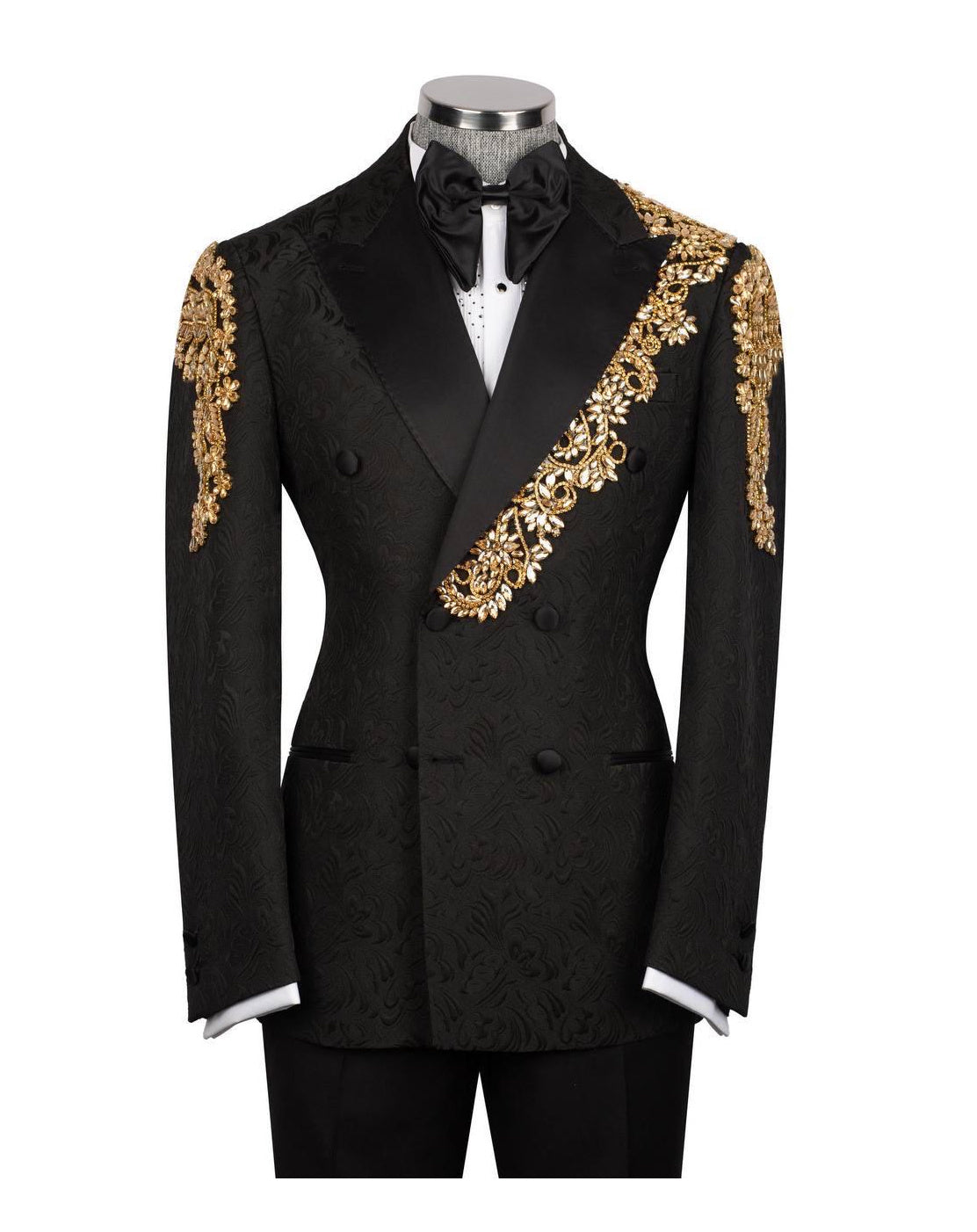 A black double-breasted tuxedo jacket with ornate gold embroidered detailing on the shoulders and a diagonal chest panel, displayed on a mannequin with a black bow tie and white shirt.