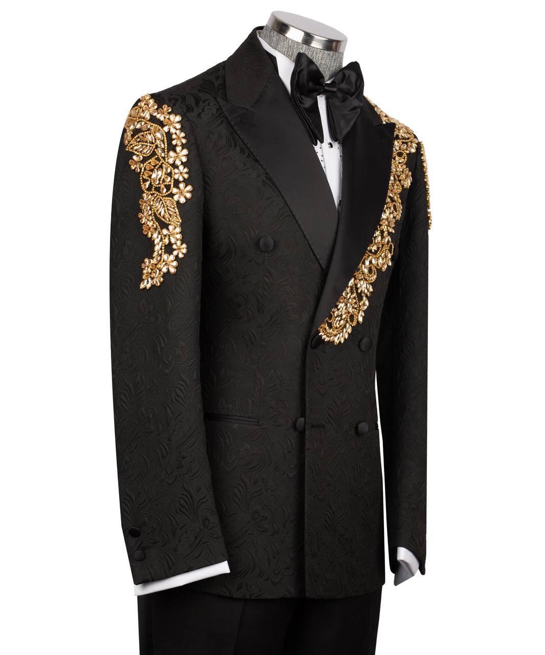 A black double-breasted tuxedo jacket with ornate gold floral embroidery on the shoulders and lapels, displayed on a mannequin with a black bow tie and white shirt.