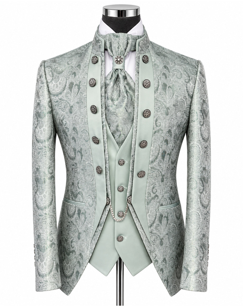 A formal menswear set on a mannequin, featuring a light sage green and gray paisley brocade jacket, matching vest, tie, and high collar with ornate silver-tone buttons.