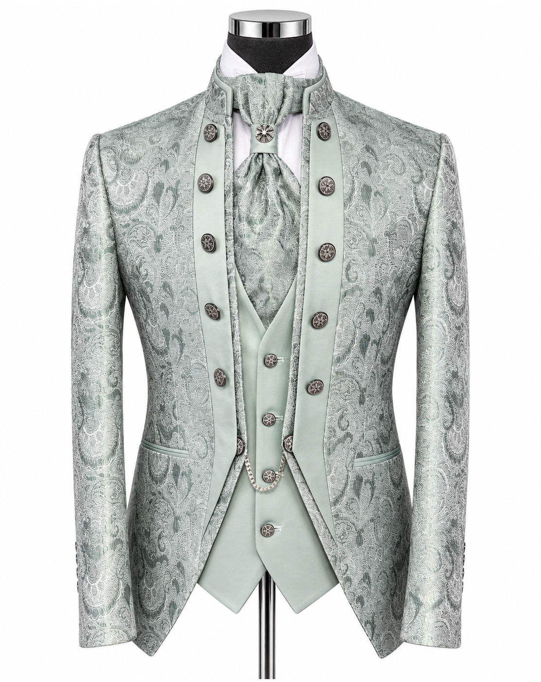 A formal menswear set on a mannequin, featuring a light sage green and gray paisley brocade jacket, matching vest, tie, and high collar with ornate silver-tone buttons.