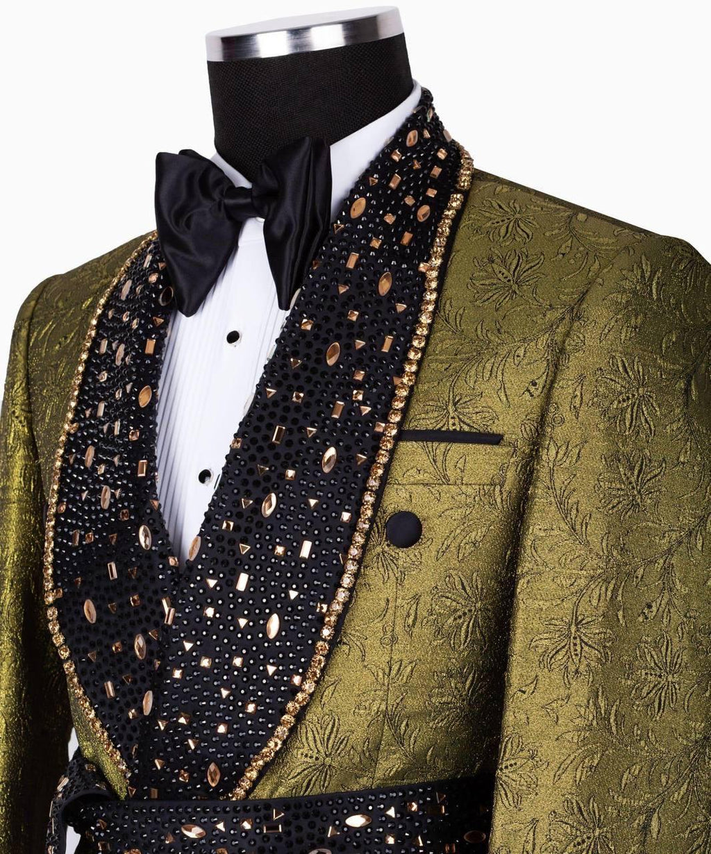 A men's formal tuxedo jacket in olive green jacquard fabric with a black beaded shawl collar, gold trim, a white pleated shirt, and a black bow tie, displayed on a mannequin torso.