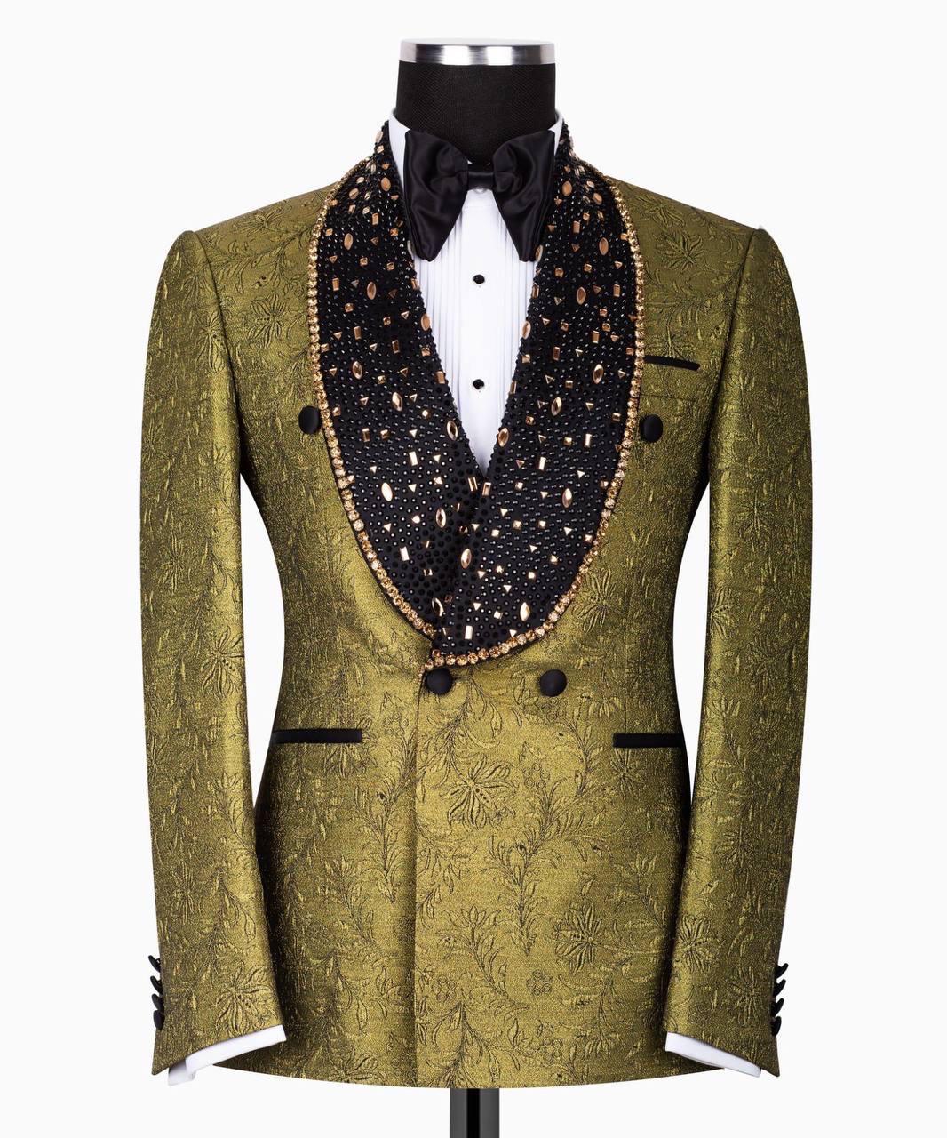 An olive green double-breasted tuxedo jacket with a black beaded peak lapel, styled on a black mannequin torso with a white pleated shirt and black bow tie against a white background.