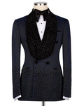 A black double-breasted tuxedo jacket embellished with sparkling rhinestones, styled on a mannequin with a white dress shirt, black bow tie, and a large black beaded collar.
