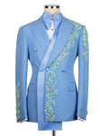 A light blue double-breasted tuxedo jacket with intricate turquoise and gold floral embroidery along the lapels and sleeves, displayed on a mannequin with a matching light blue satin bow tie and white shirt.