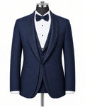 A navy blue formal tuxedo jacket with textured shawl lapels, displayed on a mannequin with a matching navy bow tie, white pinstriped shirt, and matching textured vest against a plain white background.