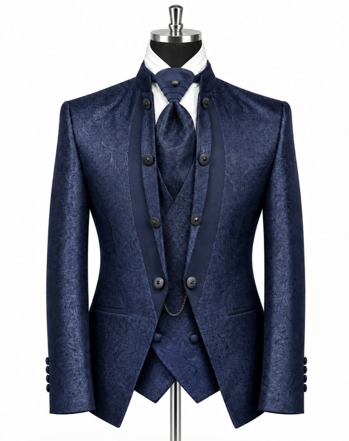 A men's three-piece suit in a textured navy blue fabric, displayed on a black mannequin with a white dress shirt and matching tie against a plain white background.