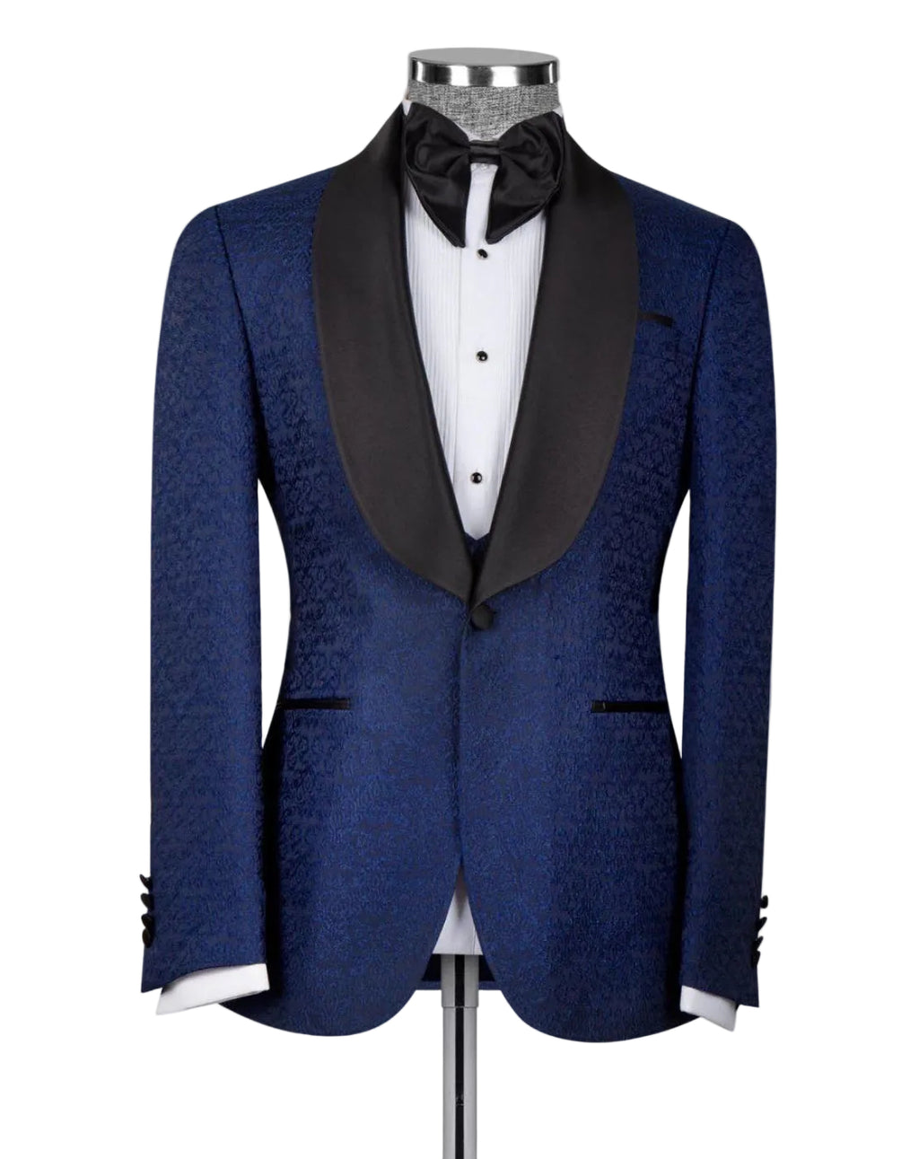 A men's tuxedo jacket displayed on a mannequin, featuring a textured royal blue jacquard body with contrasting black satin shawl collar, paired with a white dress shirt and black bow tie.