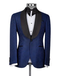 A men's tuxedo jacket displayed on a mannequin, featuring a textured royal blue jacquard body with contrasting black satin shawl collar, paired with a white dress shirt and black bow tie.