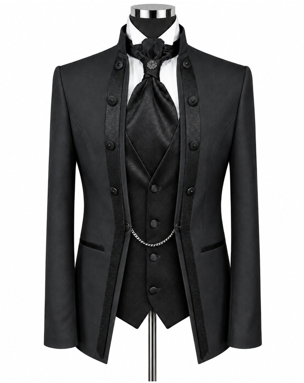 A black formal men's suit set displayed on a mannequin, featuring a double-breasted jacket with satin lapels, a matching vest, a white shirt, a black tie, and a silver chain detail.