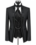 A black formal men's suit set displayed on a mannequin, featuring a double-breasted jacket with satin lapels, a matching vest, a white shirt, a black tie, and a silver chain detail.