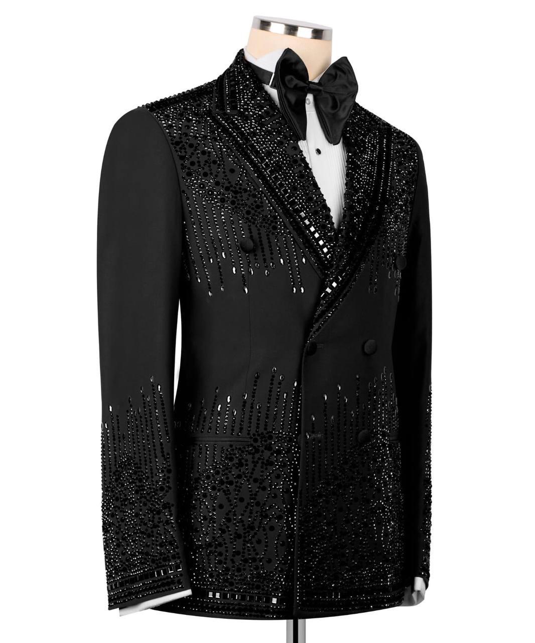 A black tuxedo jacket with extensive silver bead and sequin embellishments, styled on a mannequin with a black bow tie and white shirt against a white background.