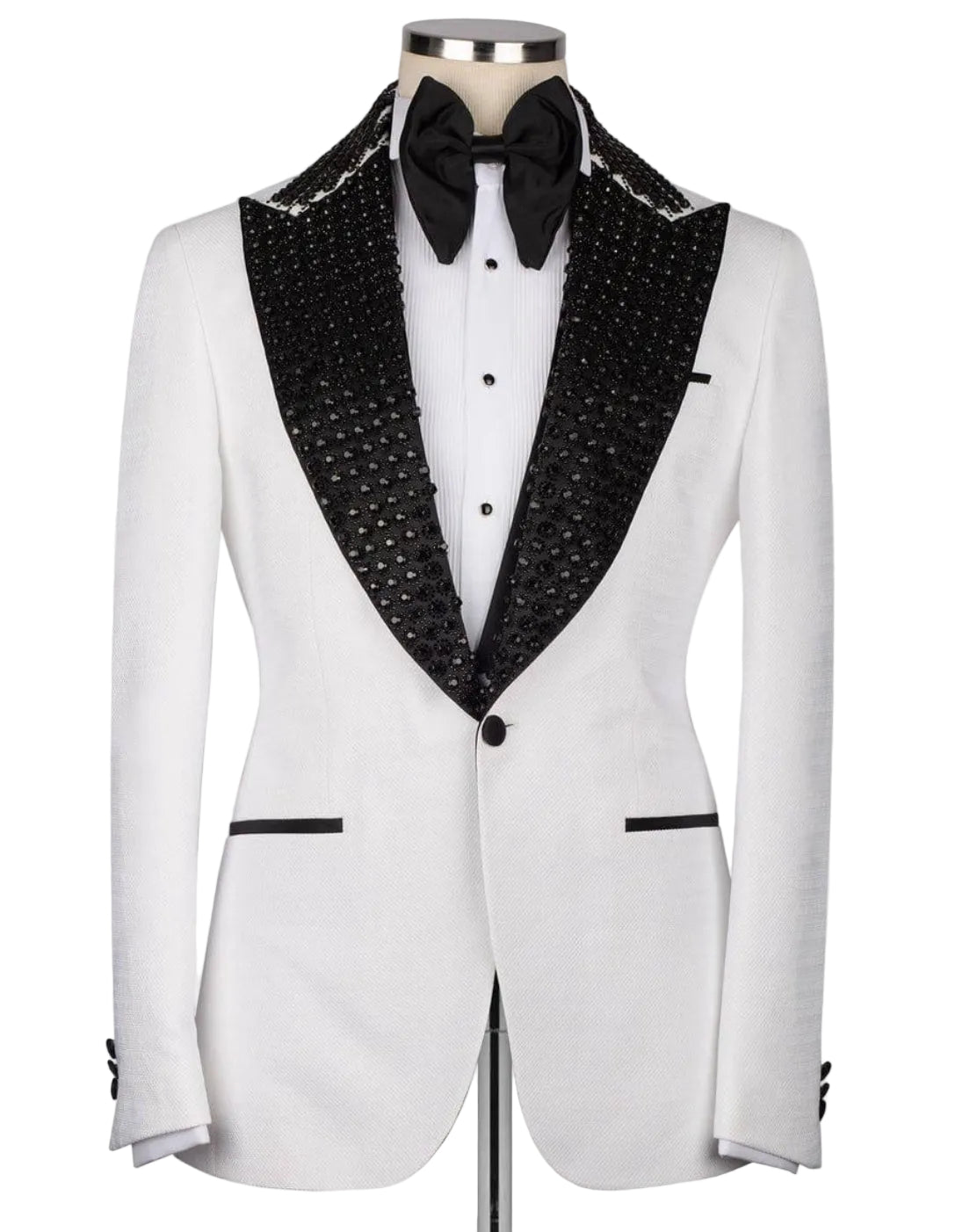 A white tuxedo jacket with black beaded shawl lapels, displayed on a mannequin with a white dress shirt, black bow tie, and black cufflinks against a light gray background.