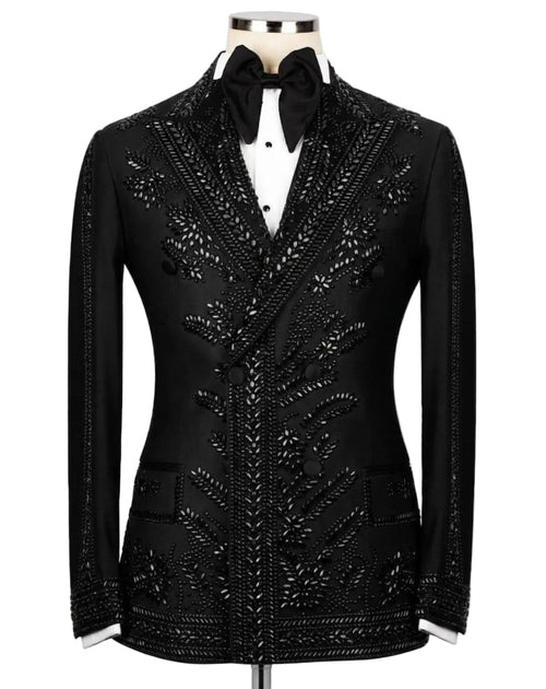 A black tuxedo jacket with intricate silver beaded and sequined floral patterns, styled on a mannequin with a white shirt and black bow tie against a light gray background.