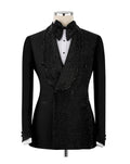A black double-breasted tuxedo jacket with heavy bead and sequin embellishments, styled on a mannequin with a black bow tie, white pleated shirt, and black vest.