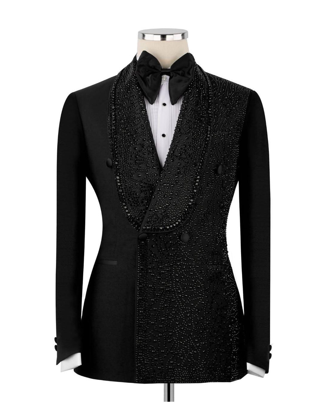 A black double-breasted tuxedo jacket with heavy bead and sequin embellishments, styled on a mannequin with a black bow tie, white pleated shirt, and black vest.