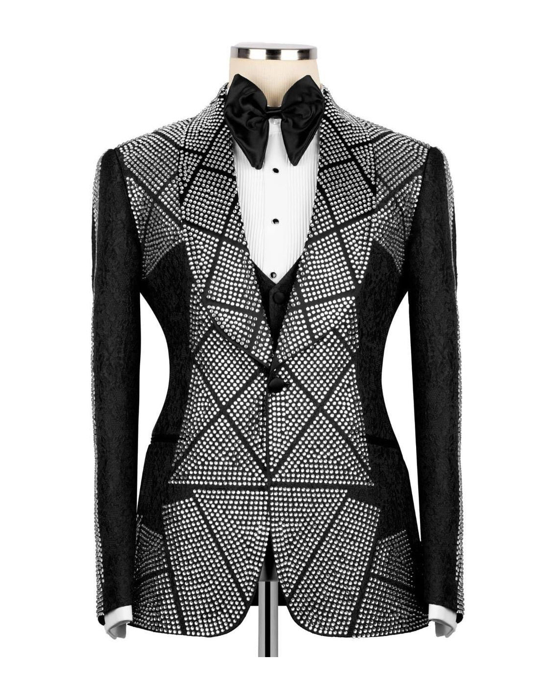 A men's tuxedo jacket with a black and white geometric rhinestone pattern, displayed on a mannequin with a black bow tie and white pleated shirt.