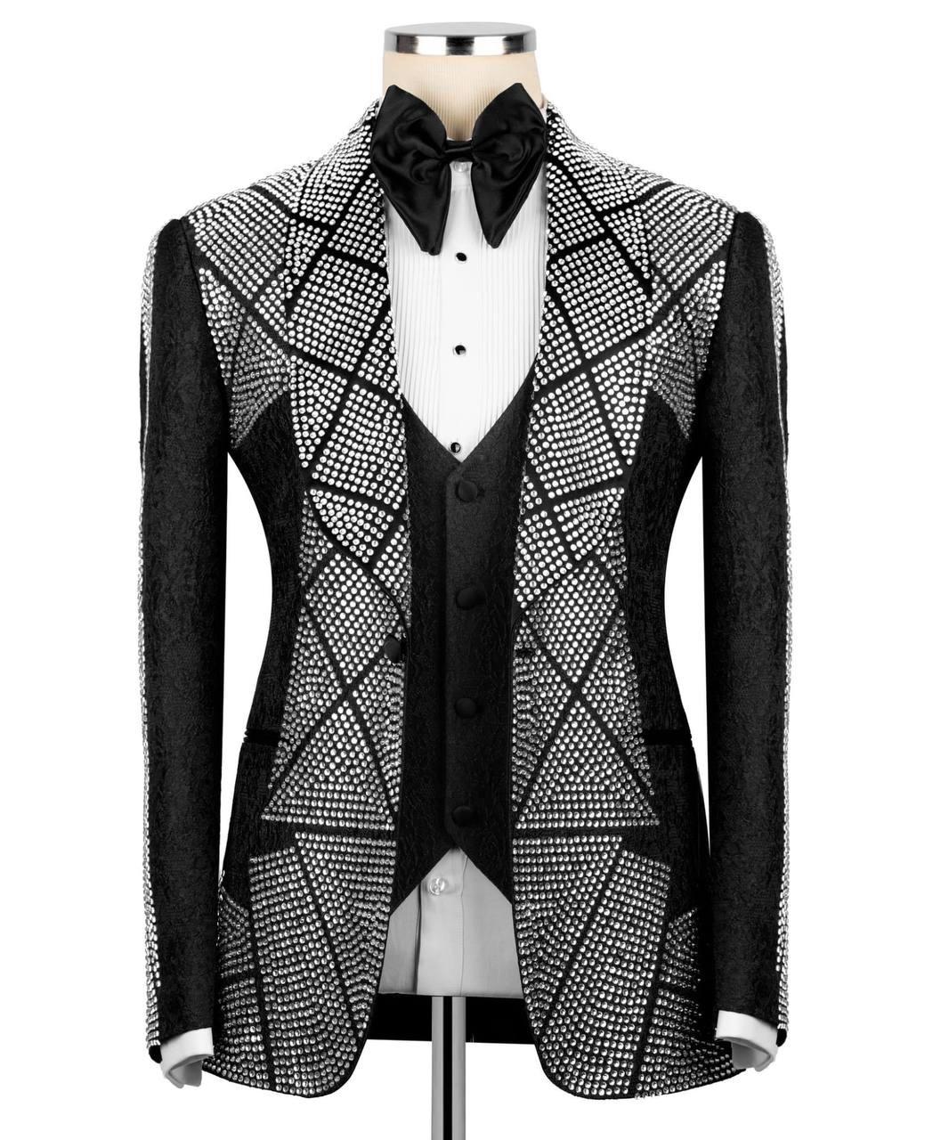 A men's tuxedo jacket with a black and white geometric rhinestone pattern, styled on a mannequin with a black vest, white shirt, and black bow tie.