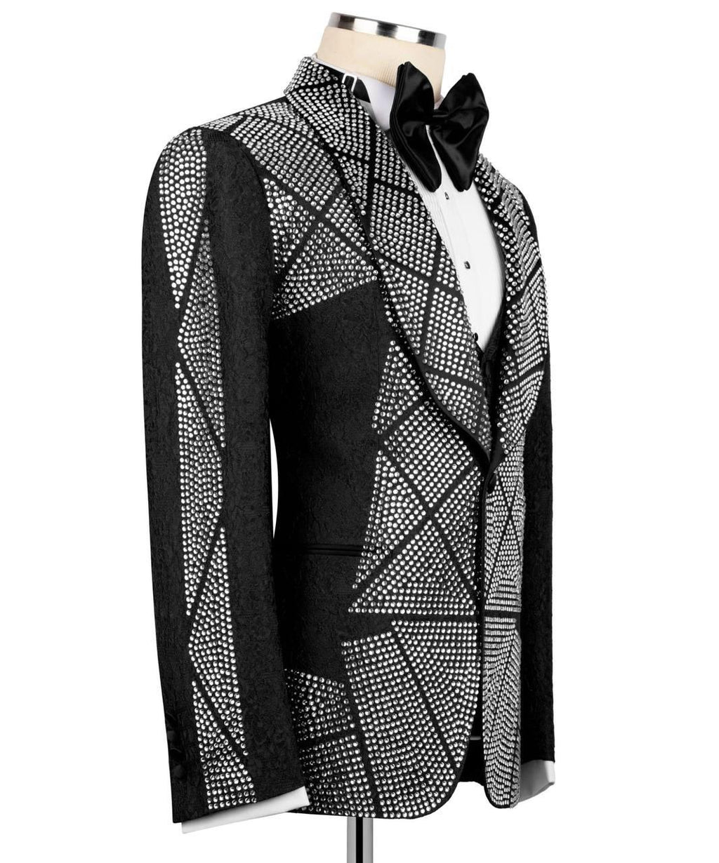 A men's tuxedo jacket with a black and white geometric rhinestone pattern, displayed on a mannequin with a black bow tie and white dress shirt.