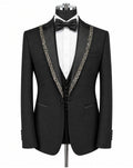 A black tuxedo jacket displayed on a mannequin with a white dress shirt, black bow tie, and matching black vest. The jacket features ornate silver beaded trim along the notched lapels.