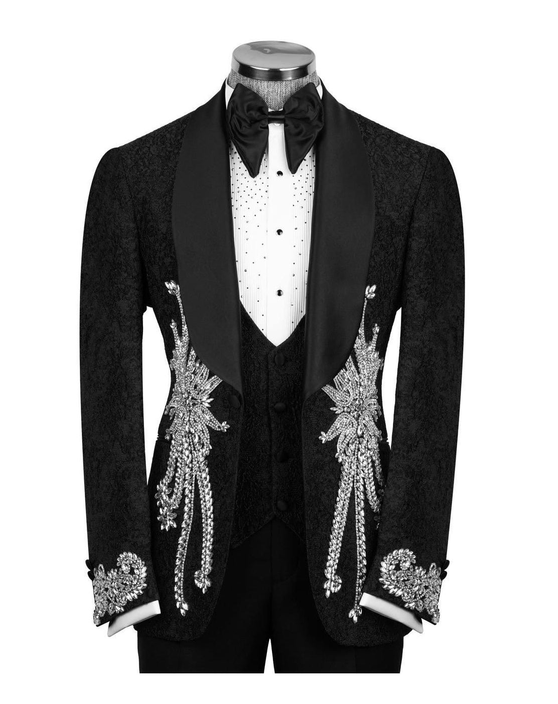 A black tuxedo jacket with ornate silver beadwork and embroidery on the front and cuffs, displayed on a mannequin with a white polka-dot shirt, black bow tie, and black vest against a plain white background.