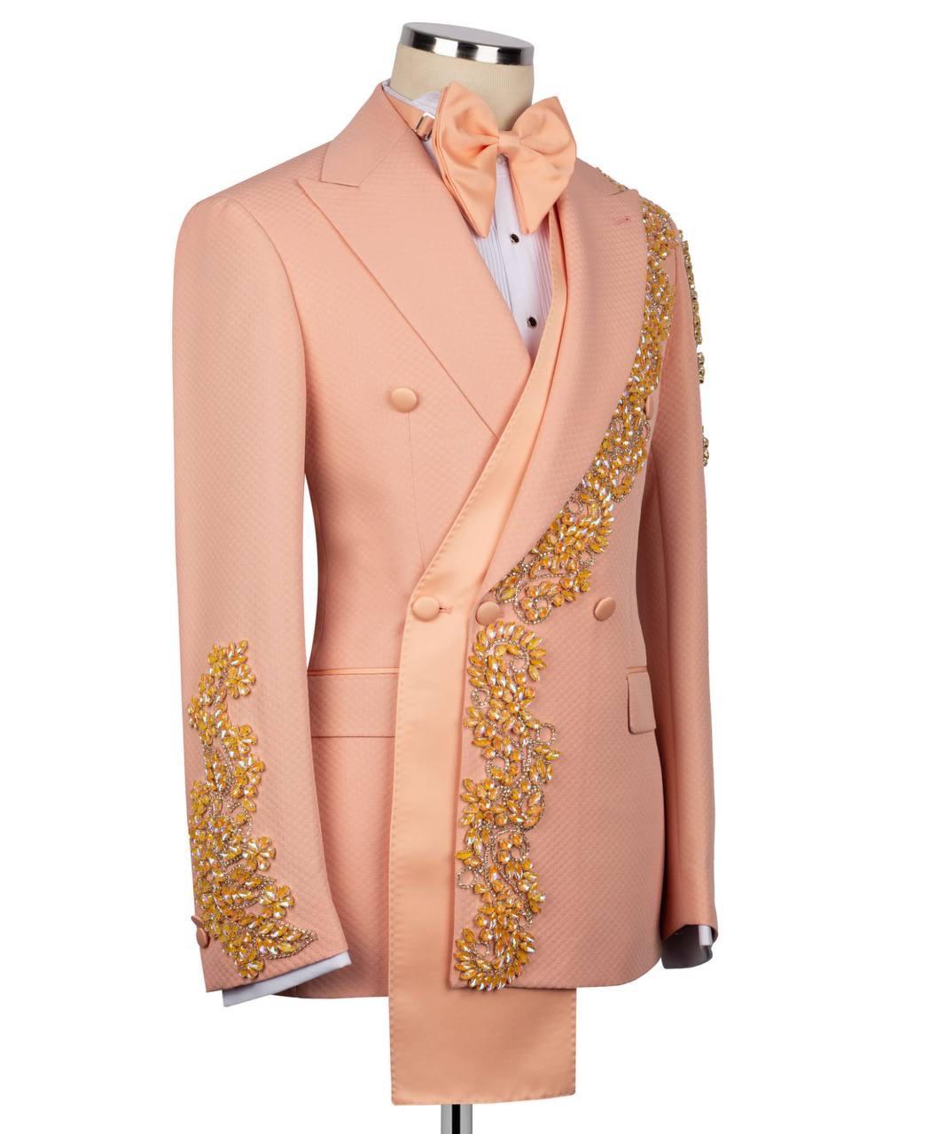 A peach-colored double-breasted tuxedo jacket with gold and yellow beaded embellishments on the lapels and sleeves, displayed on a mannequin with a matching peach bow tie and white shirt.
