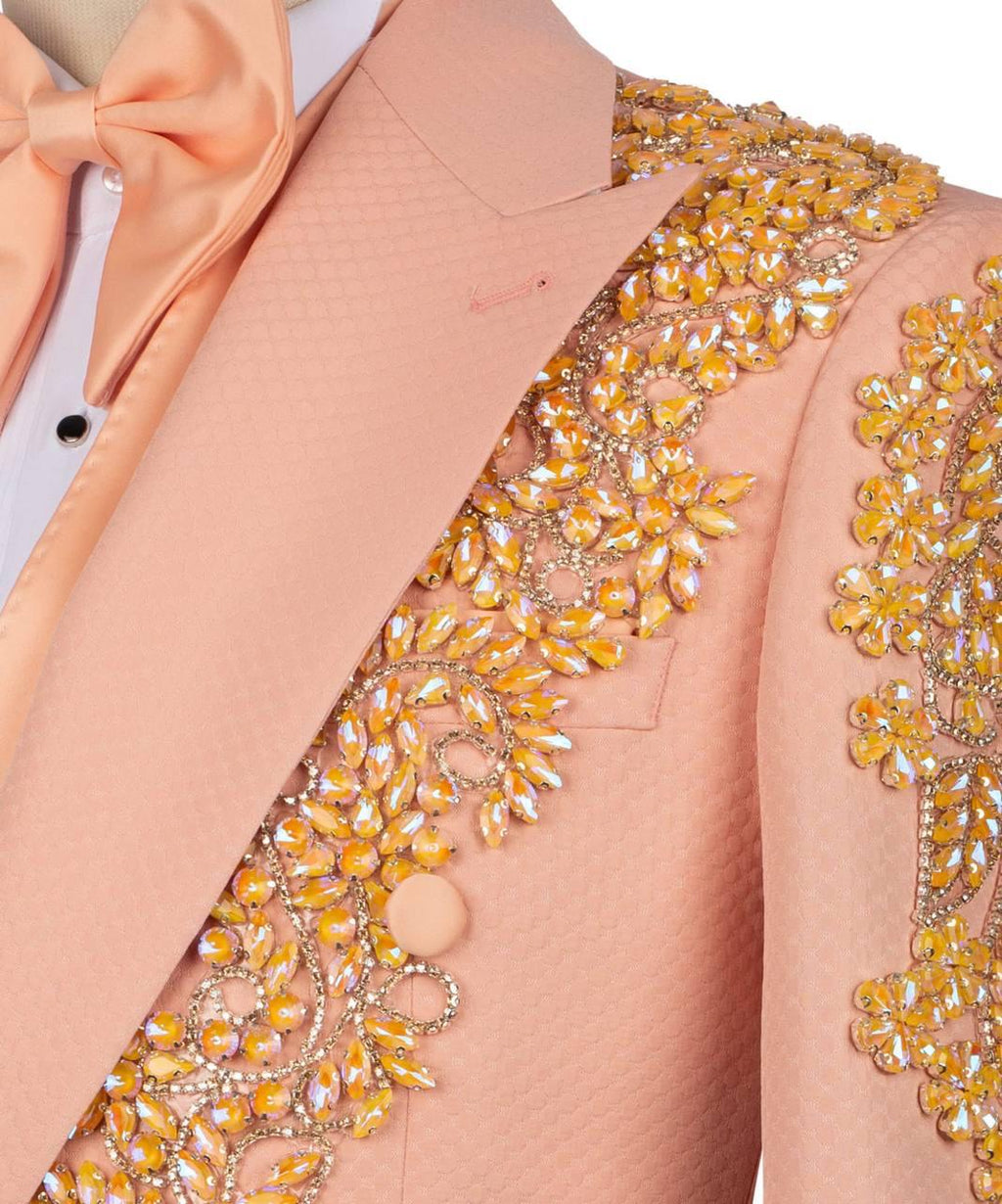 Close-up of a peach-colored blazer with intricate gold embroidery on a white background