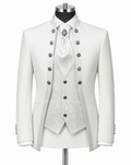 An ornate white formal suit displayed on a mannequin, featuring a double-breasted jacket with silver buttons, a matching patterned waistcoat, white shirt, and a white cravat with a decorative brooch.