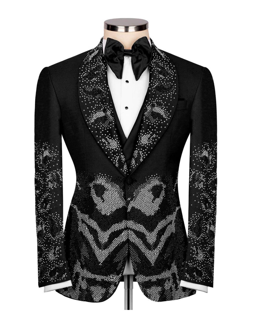 A black tuxedo jacket with ornate silver rhinestone patterns on the shawl collar, front panel, and sleeves, styled on a mannequin with a white dress shirt and black bow tie against a white background.