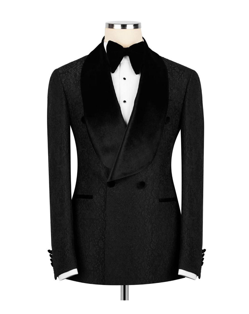 A black double-breasted tuxedo jacket with a textured pattern, black satin shawl collar, and black bow tie, displayed on a mannequin torso with a white shirt.