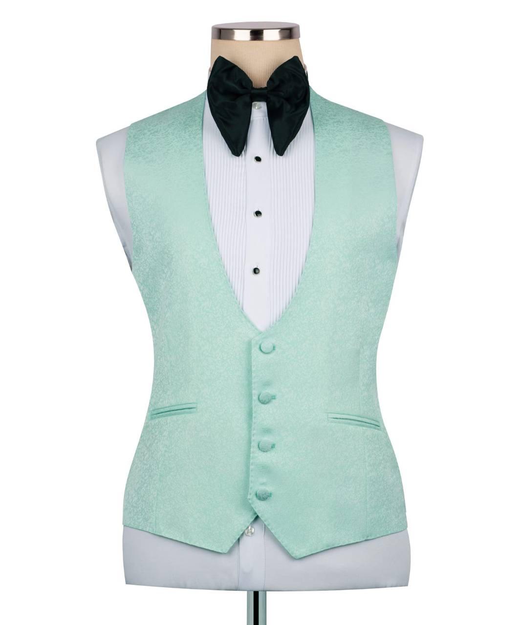 A mint green tuxedo vest displayed on a mannequin torso, styled with a white pinstripe shirt, a black velvet bow tie, and a white dress shirt against a plain white background.