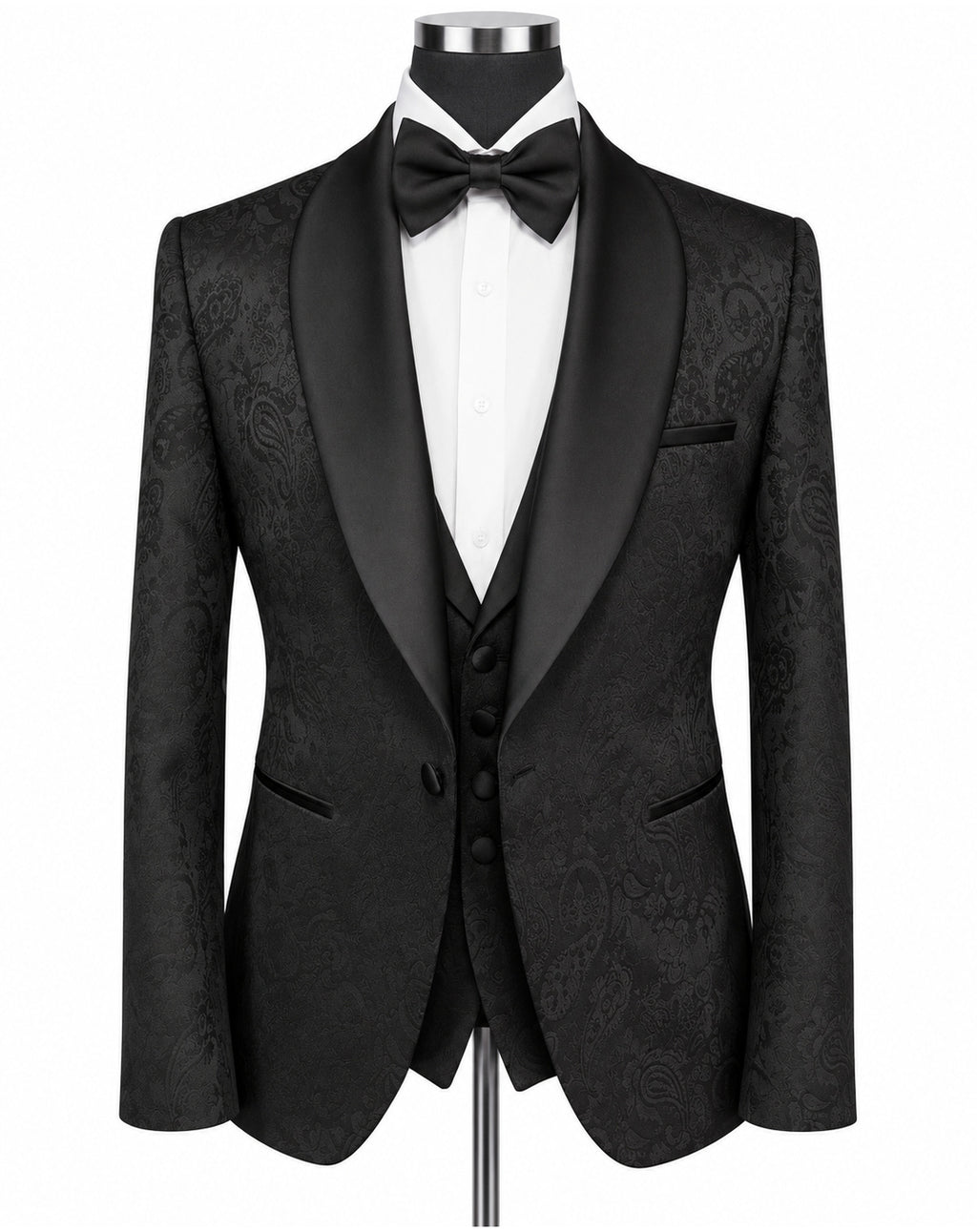 A men's formal tuxedo jacket with black satin shawl collar, black paisley brocade fabric body, paired with a matching black vest, black bow tie, and white dress shirt on a mannequin torso.