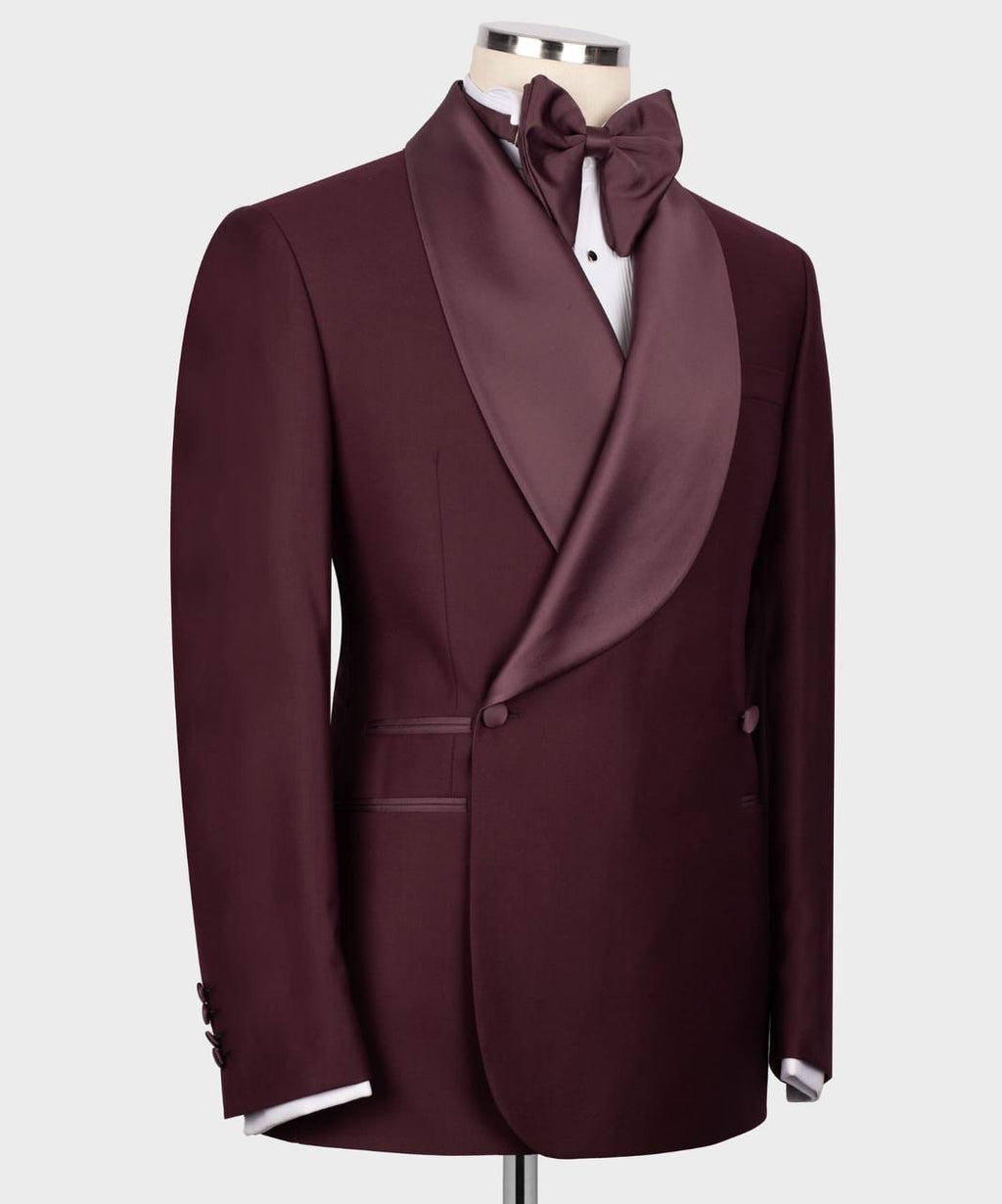 A men's formal tuxedo jacket in deep burgundy with satin shawl lapels, displayed on a mannequin torso with a matching bow tie and white dress shirt against a light gray background.