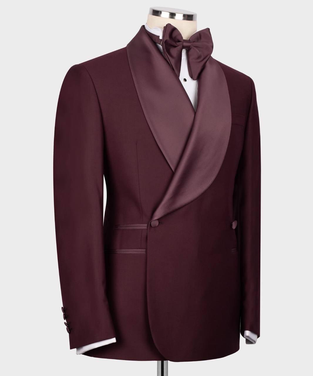 A men's formal tuxedo jacket in deep burgundy with satin shawl lapels, displayed on a mannequin torso with a matching bow tie and white dress shirt against a light gray background.