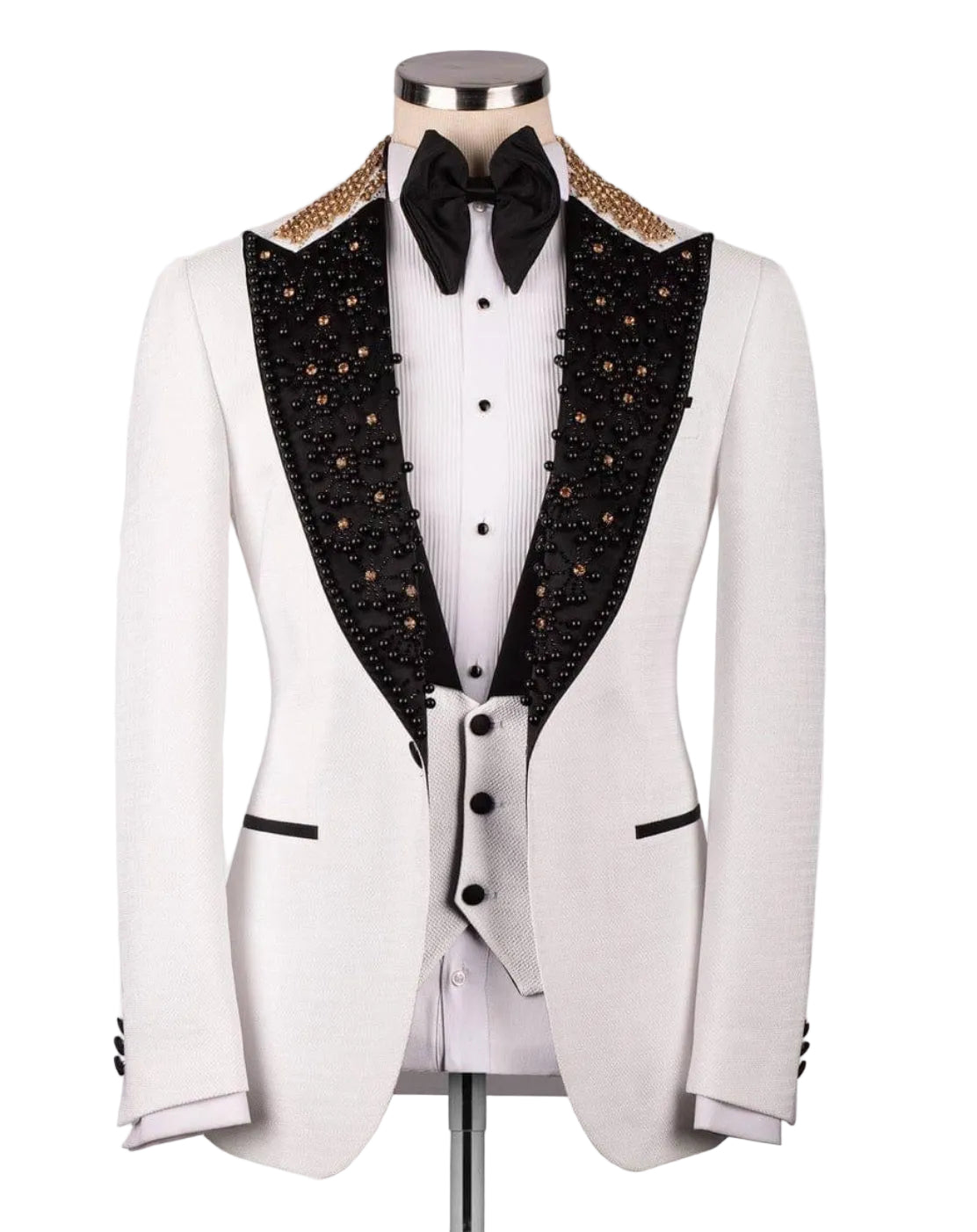 A white tuxedo jacket displayed on a mannequin, featuring black peak lapels heavily embellished with gold and black beads, a white pinstripe shirt, a black bow tie, and a matching white vest.
