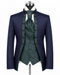 A men's formalwear outfit displayed on a mannequin against a plain white background, featuring a navy blue tailcoat jacket, a dark green patterned waistcoat, matching green patterned cravat, white shirt, and dark buttons.