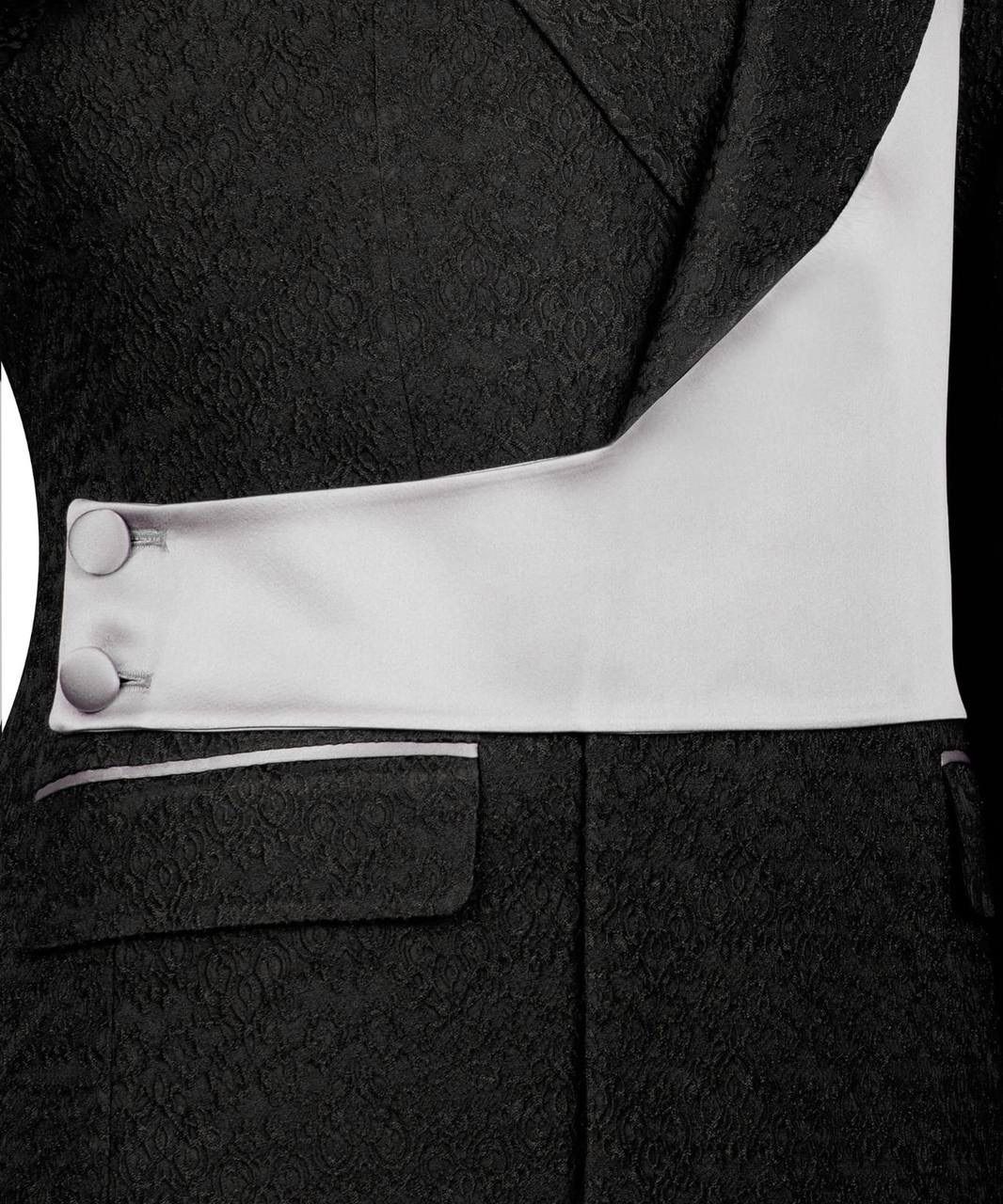 Close-up of a black suit with white lining and buttons on a black background