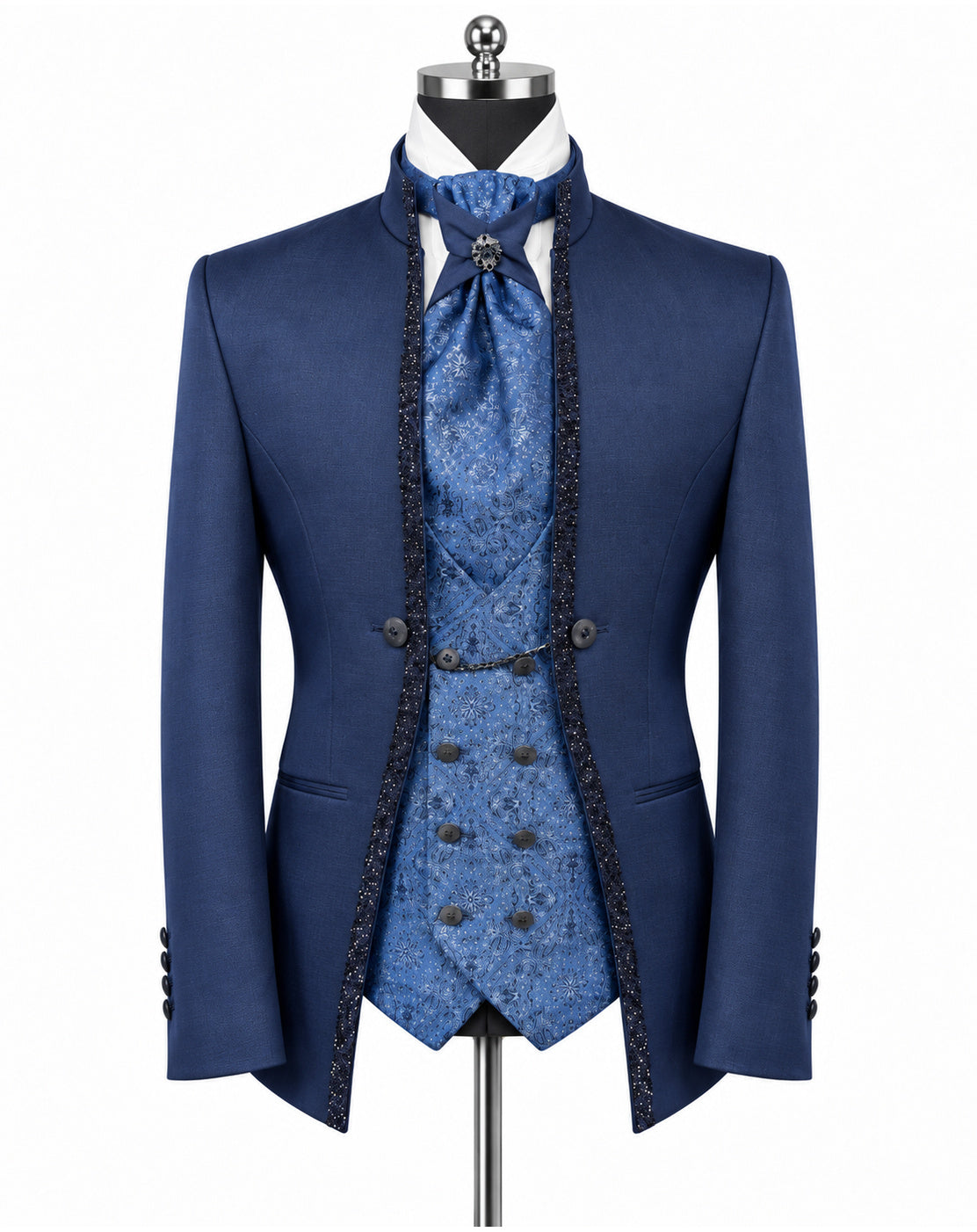 A men's formal suit displayed on a mannequin against a white background, featuring a navy blue double-breasted jacket with black lace trim, a matching blue patterned vest, waistcoat, and tie, and a white dress shirt.