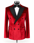 A men's double-breasted tuxedo jacket in red velvet with black satin peak lapels, displayed on a mannequin with a white dress shirt and black bow tie against a plain white background.