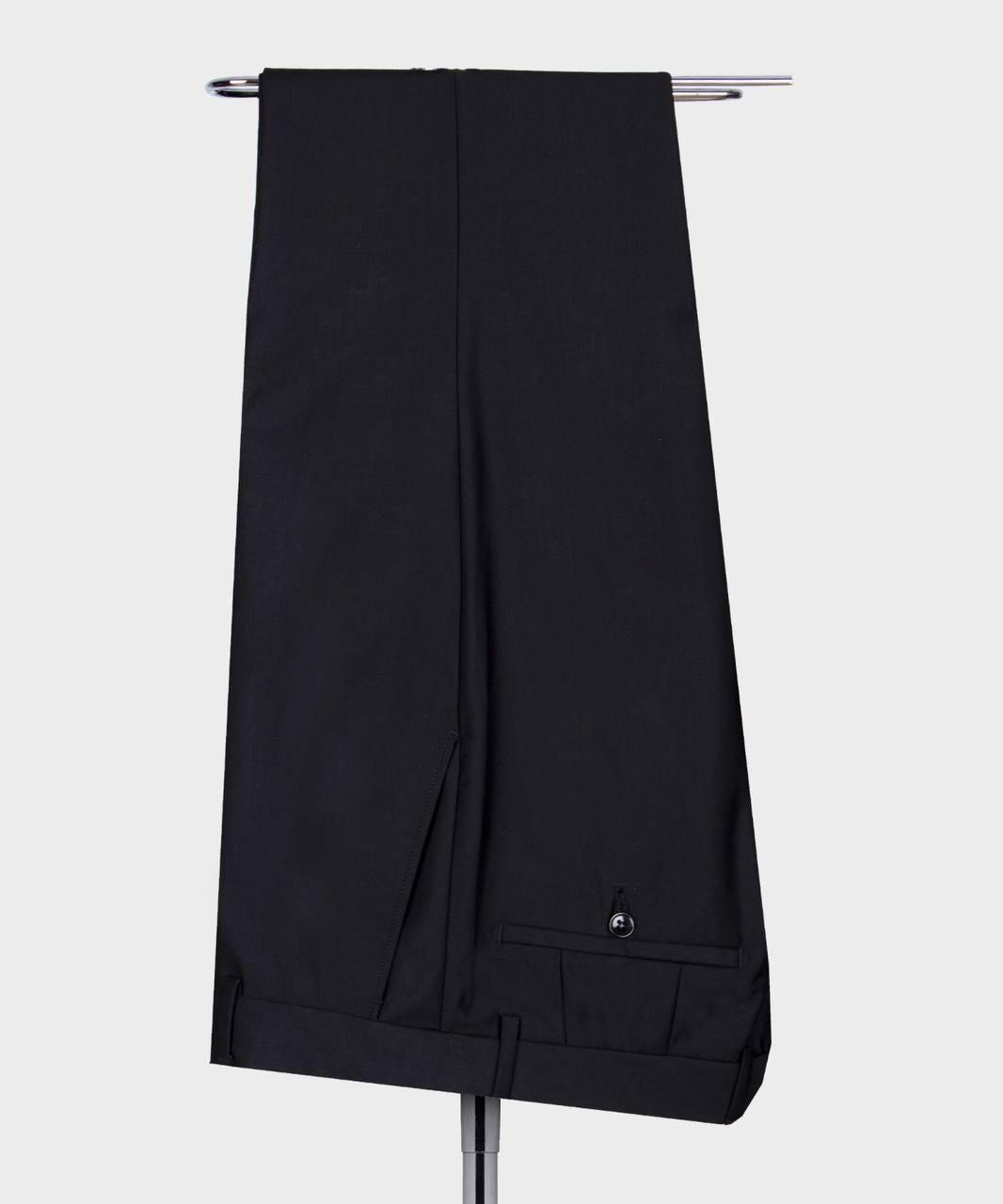 Black pants hanging on a rack against a white background