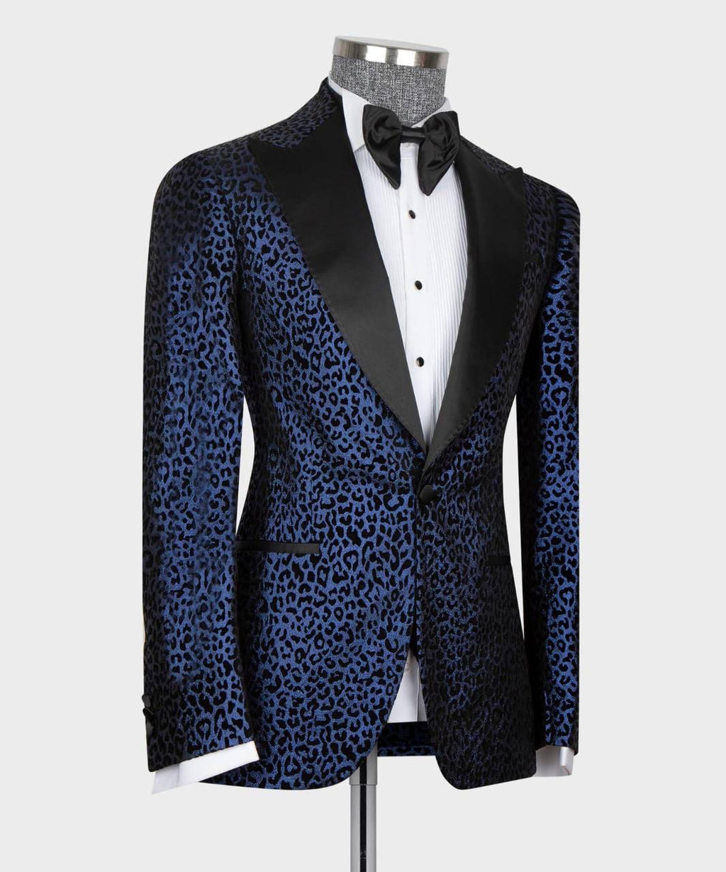 Black patterned tuxedo with navy satin lapels on a mannequin against a white background