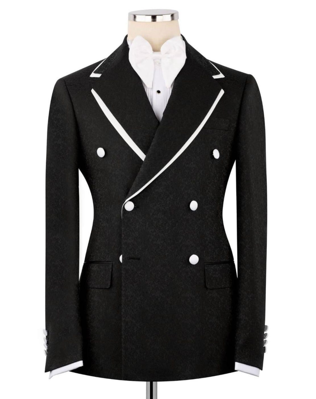 A black double-breasted blazer with white contrast piping and white buttons, displayed on a mannequin torso with a white shirt underneath, against a plain white background.
