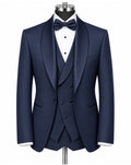A navy blue three-piece tuxedo set displayed on a mannequin, including a jacket, matching vest, and trousers, styled with a white dress shirt and a matching navy bow tie.