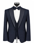 A navy blue formal tuxedo set displayed on a mannequin, featuring a satin lapel jacket, matching vest, white dress shirt, and a dark navy bow tie, set against a plain white background.