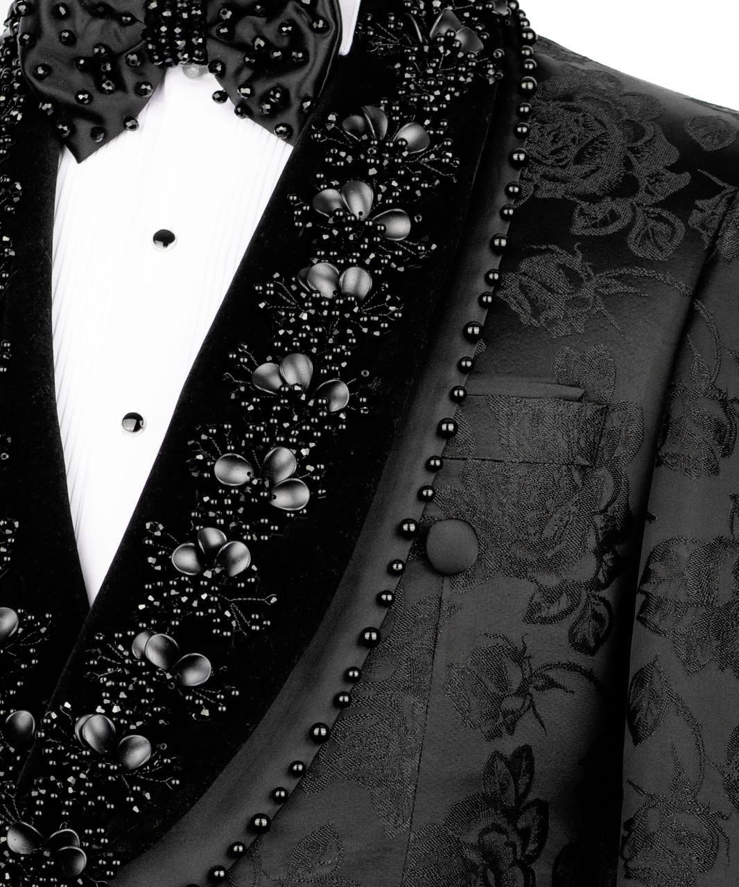 Close-up of a black tuxedo with floral patterns and buttons on a white background