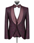 A men's formal tuxedo jacket with matching waistcoat vest, displayed on a mannequin with a white dress shirt and matching burgundy bow tie. The jacket features a subtle damask pattern in deep burgundy and purple, with satin shawl lapels.