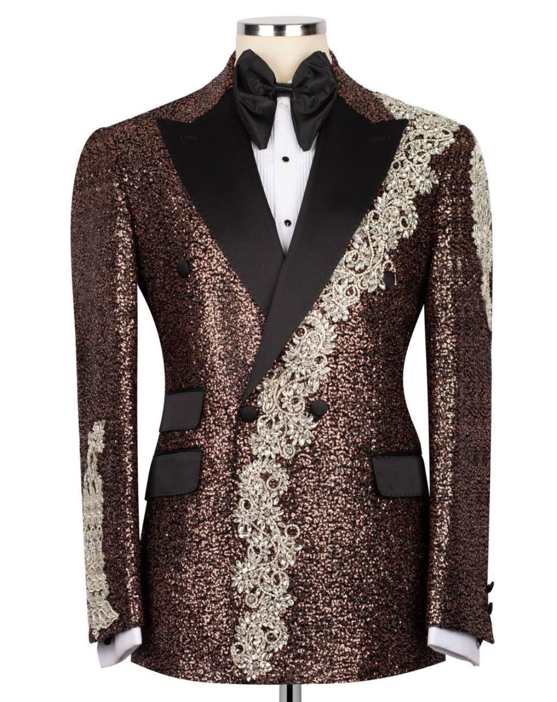 A men's formal tuxedo jacket with a brown sequined body, black satin peak lapels, a diagonal silver lace panel, and a black bow tie, displayed on a mannequin against a white background.
