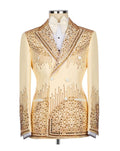 A cream-colored double-breasted tuxedo jacket heavily embellished with gold rhinestones and beadwork, displayed on a mannequin with a white shirt and bow tie.